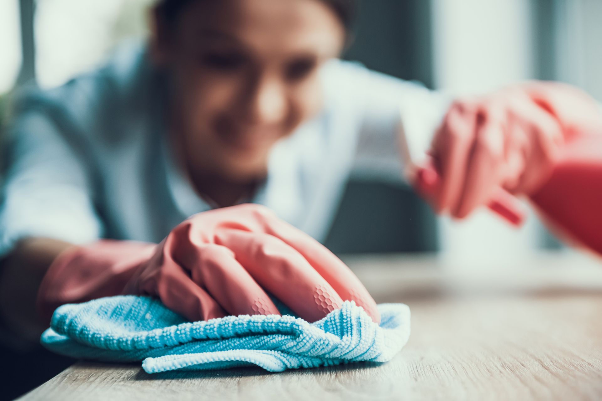 Femme nettoyant la poussière sur une table basse en bois