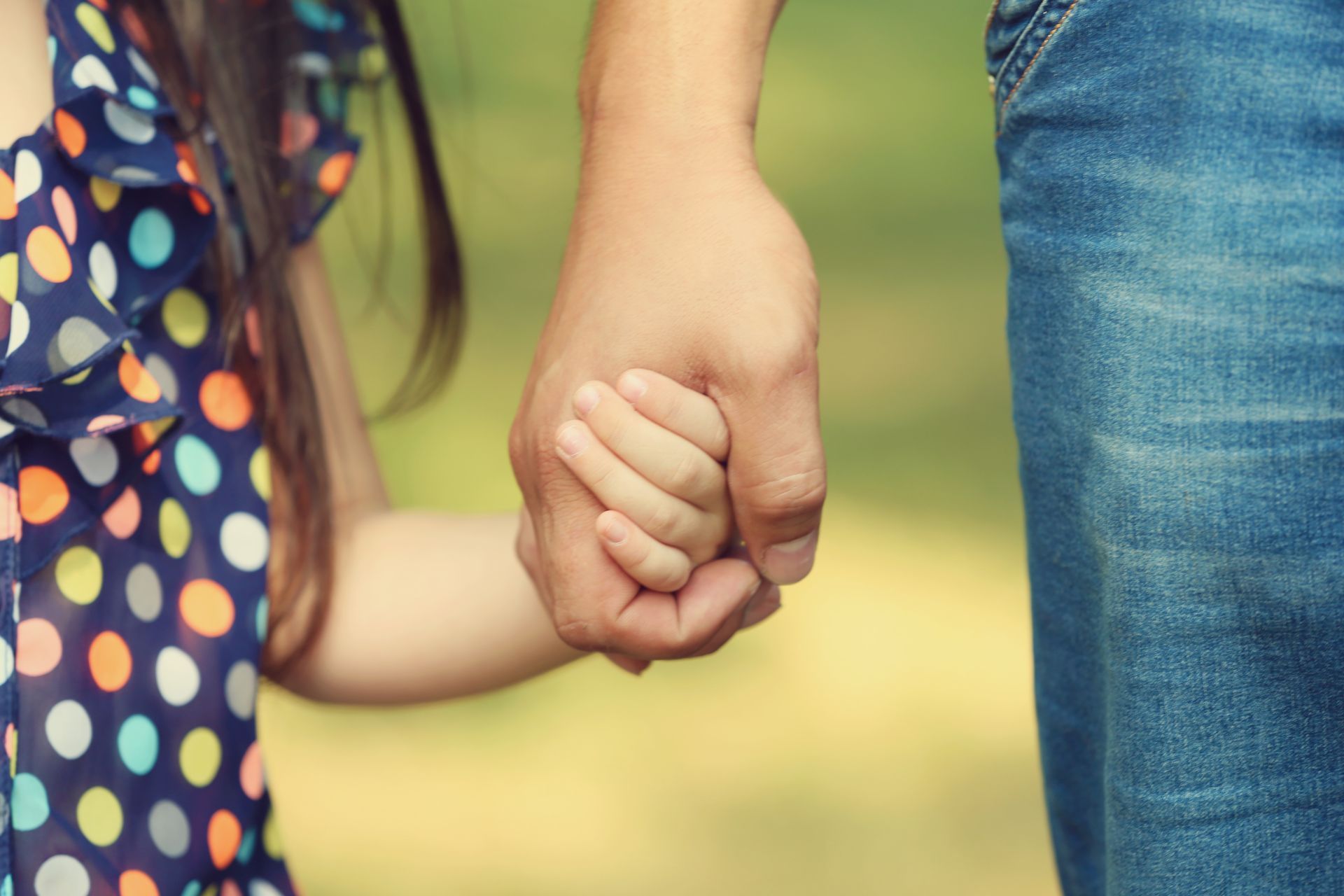 Adulte tenant une enfant par la main