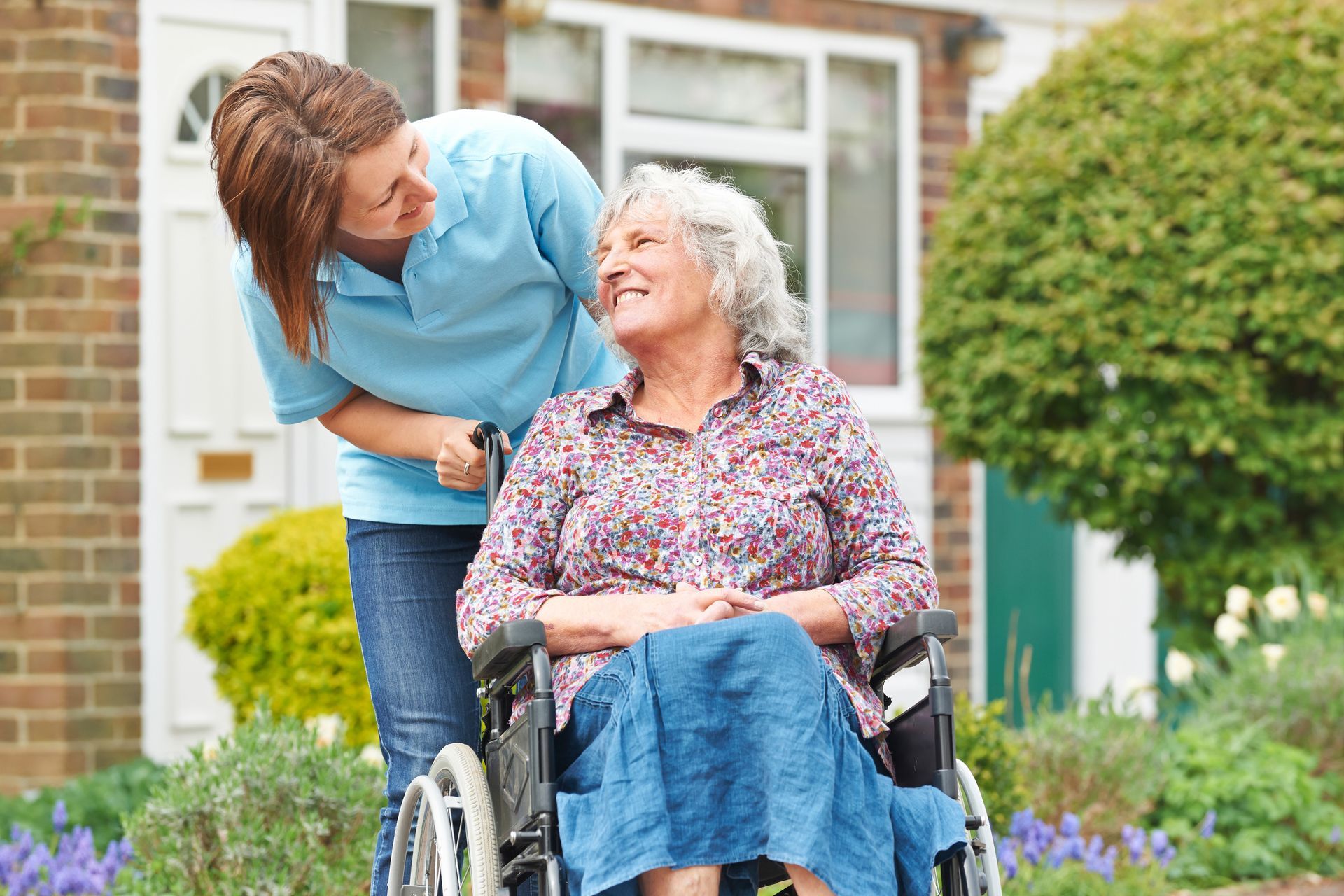 Femme s'occupant d'une dame âgée en fauteuil roulant