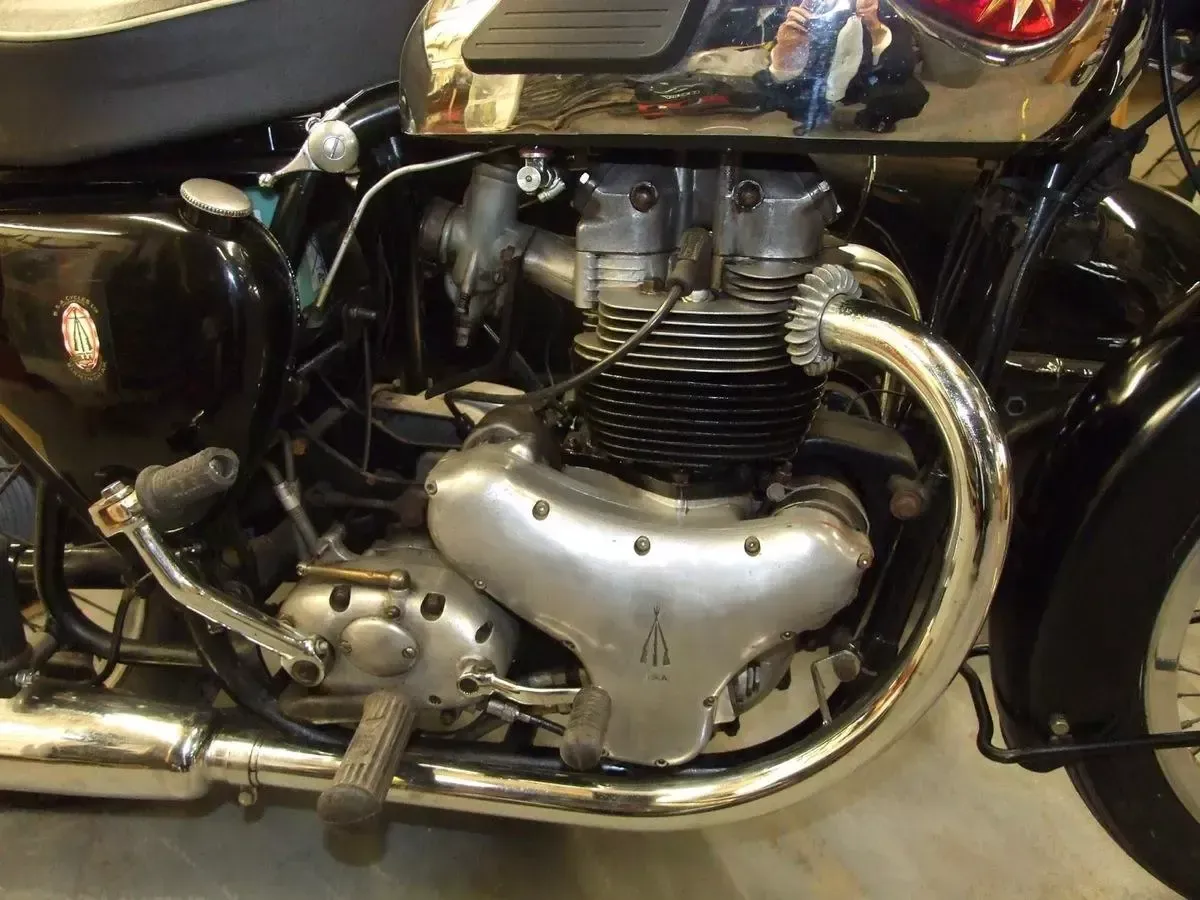 Gros plan sur un moteur de moto chromé et son échappement, sur une moto noire