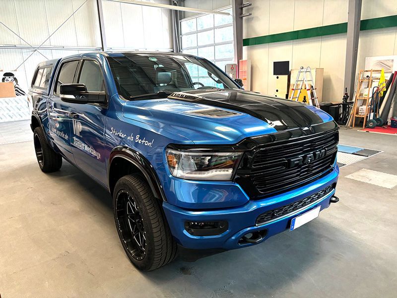 Ein blauer Ram-Truck steht in einer Garage.