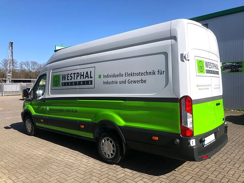 Ein grün-weißer Lieferwagen steht vor einem Gebäude.