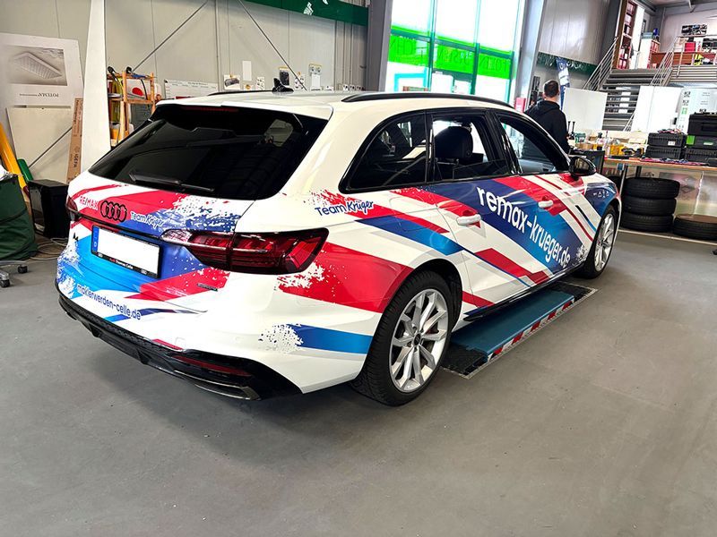 Ein rot-weiß-blaues Auto steht in einer Garage.
