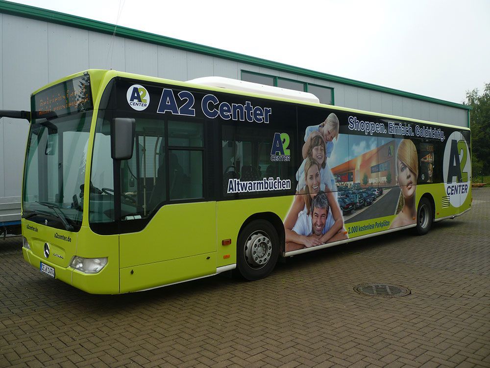 Ein gelber A2-Center-Bus steht vor einem Gebäude