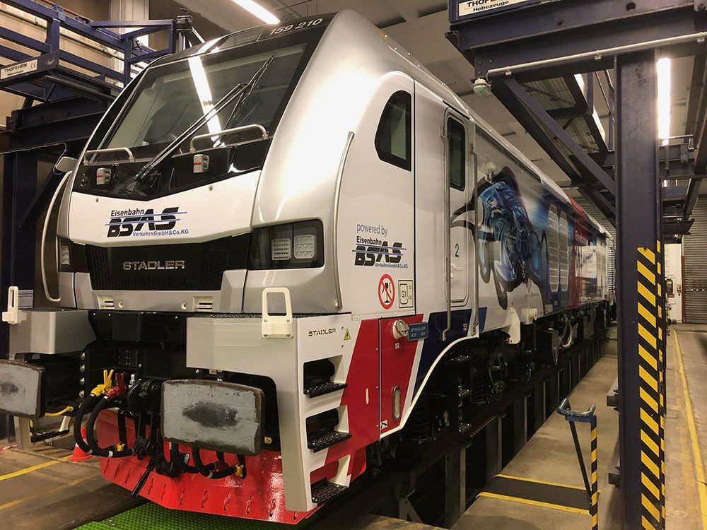 Ein rot-weiß-blauer Zug steht in einer Garage.