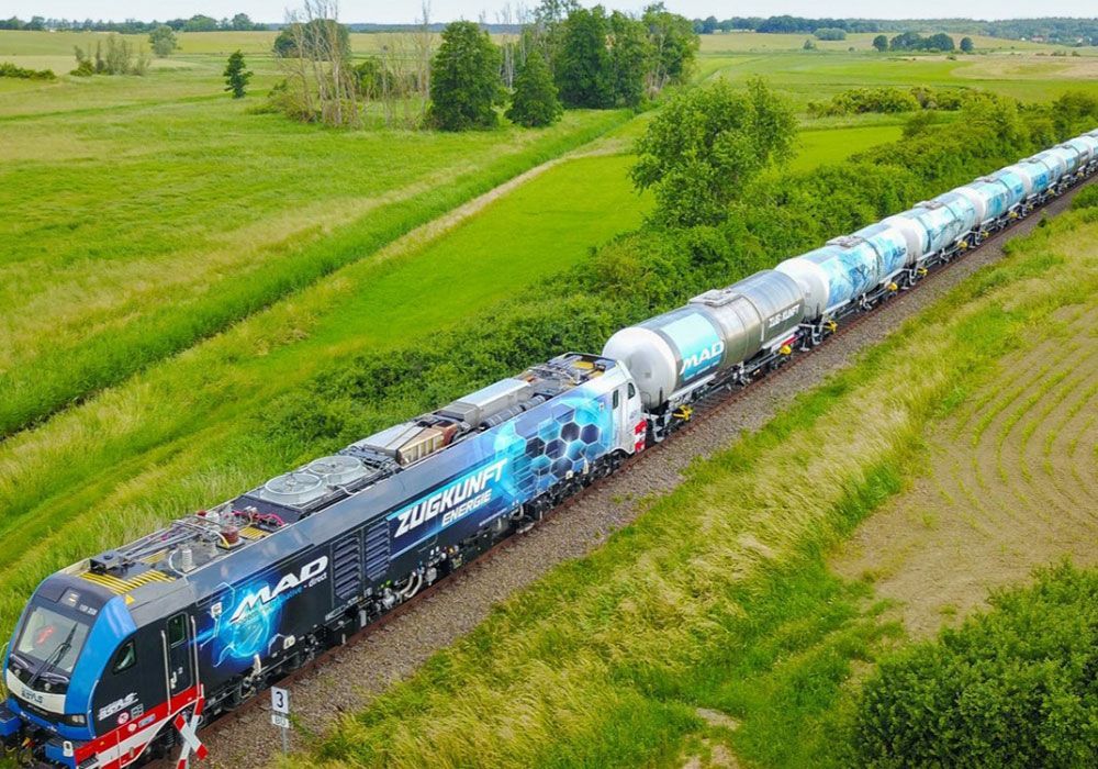 Eine Luftaufnahme eines Zuges, der durch eine Wiese fährt.