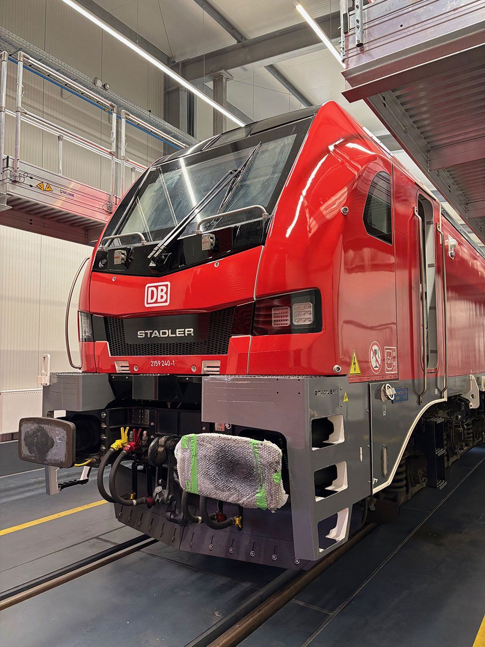 Ein roter Zug steht in einer Garage auf den Gleisen.