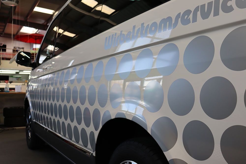 Ein weißer Lieferwagen mit Punkten und dem Wort „Service“ auf der Seite