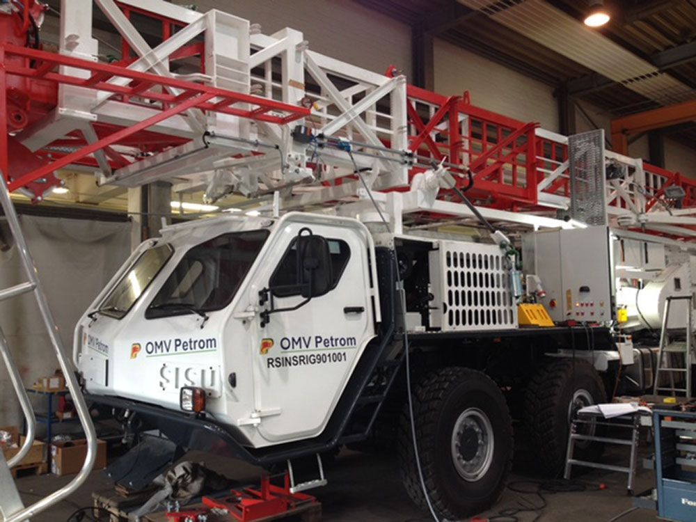 Ein weiß-roter Lastwagen steht in einer Garage.