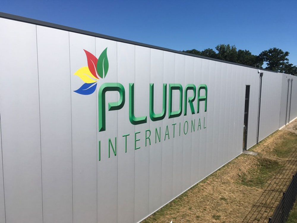 Ein Schild an einer Wand mit der Aufschrift „Pludra International“
