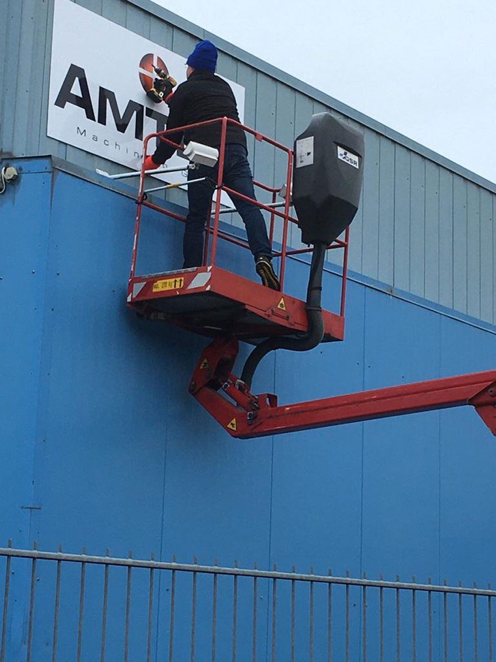 Ein Mann malt ein Schild an die Seite eines Gebäudes