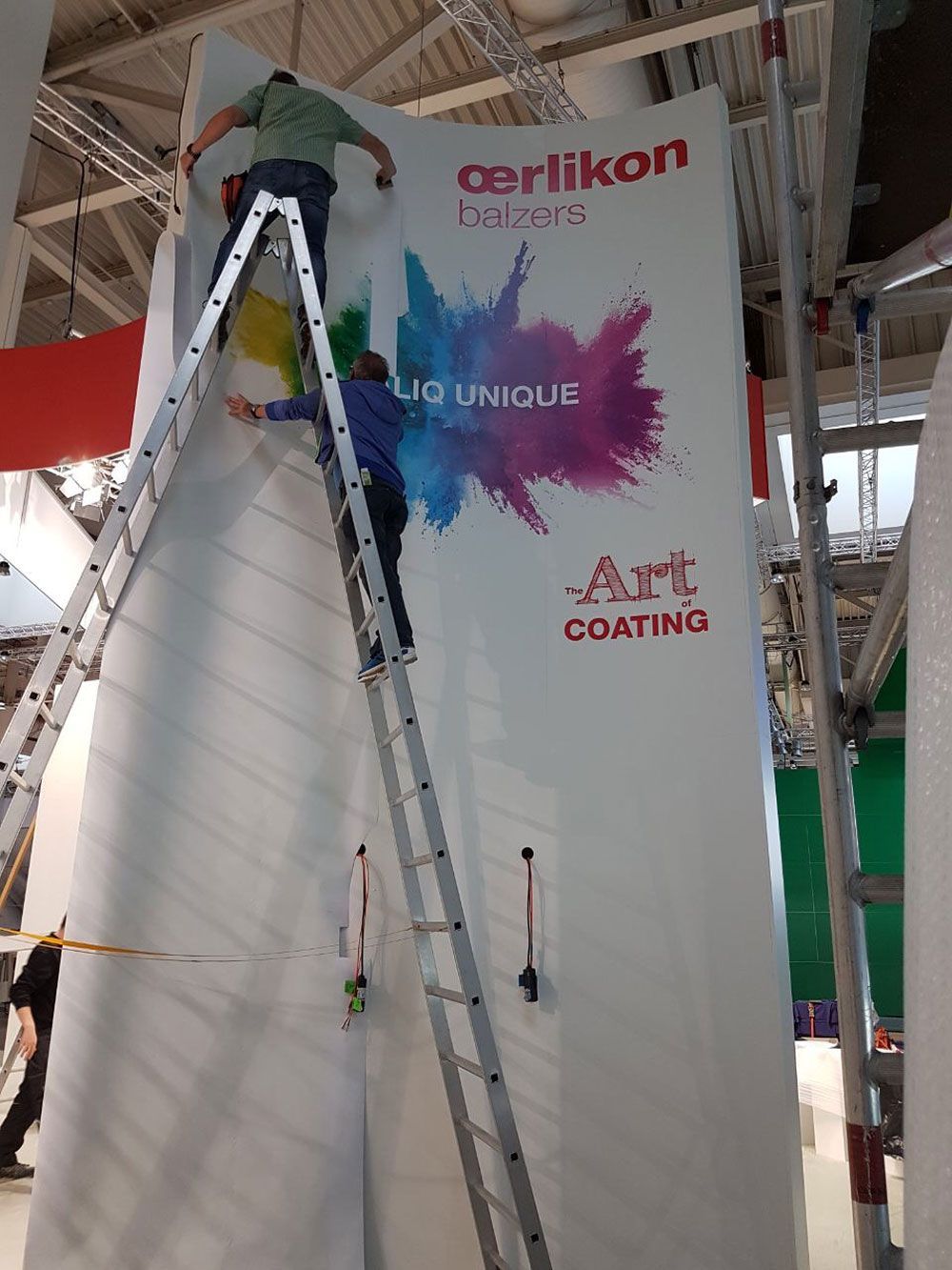 Ein Mann steht auf einer Leiter und streicht eine Wand.