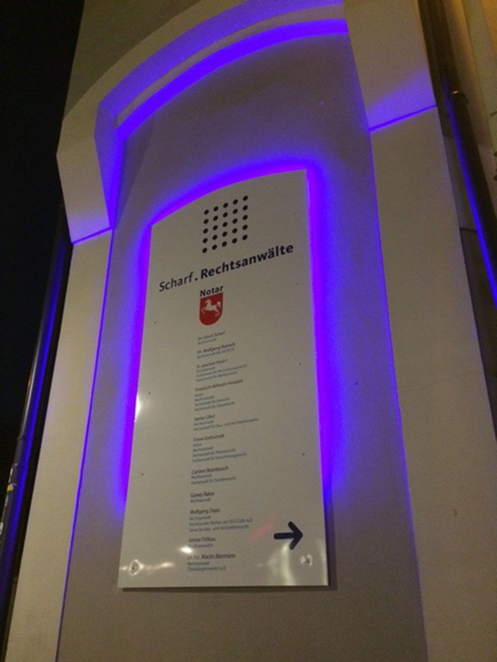 Ein Schild an der Seite eines Gebäudes weist nach rechts