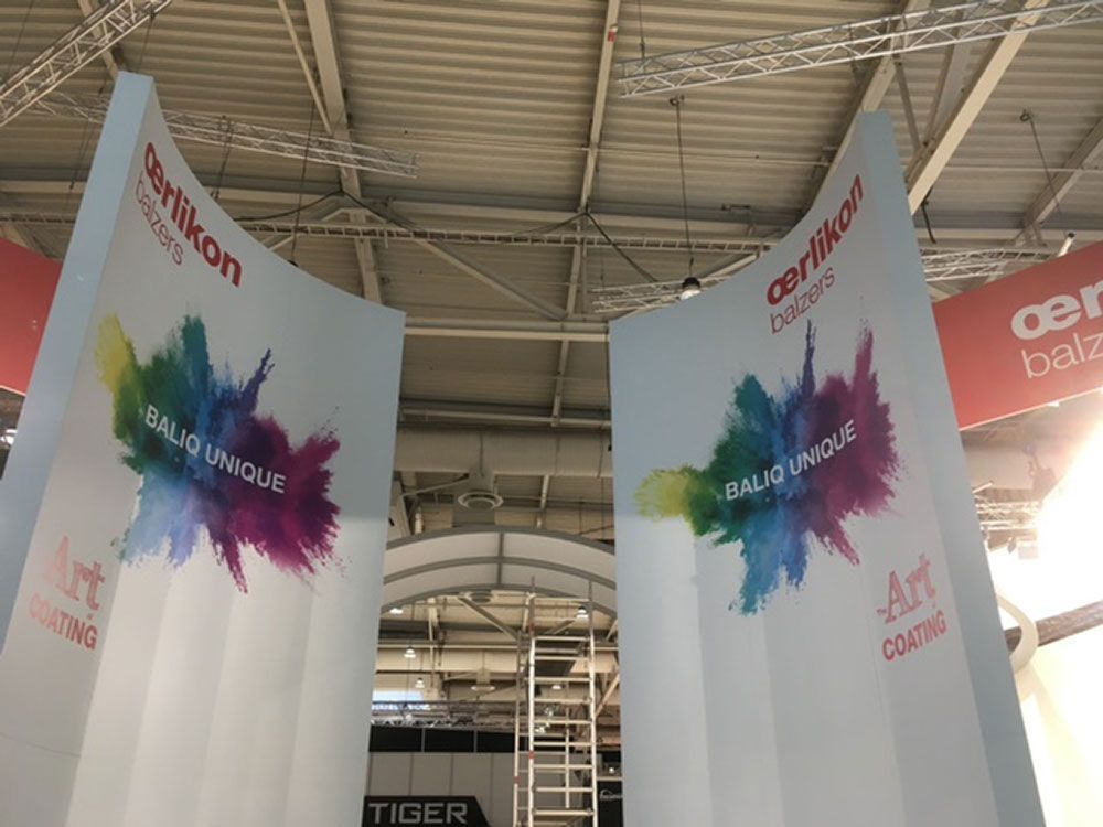 Von der Decke eines Gebäudes hängen zwei Schilder.