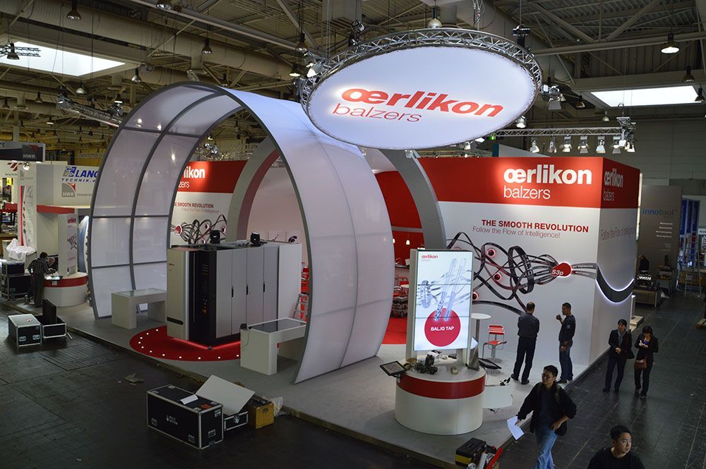Eine Gruppe von Menschen steht um ein Display für Cerlikon-Motoren herum