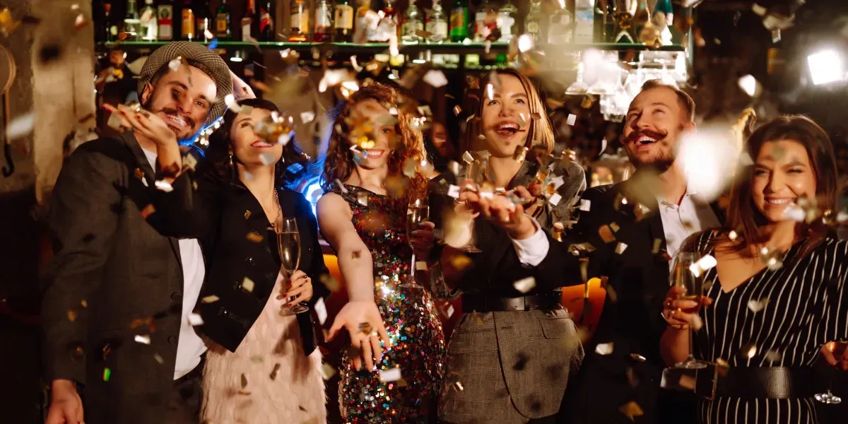 People celebrating with confetti in a bar.