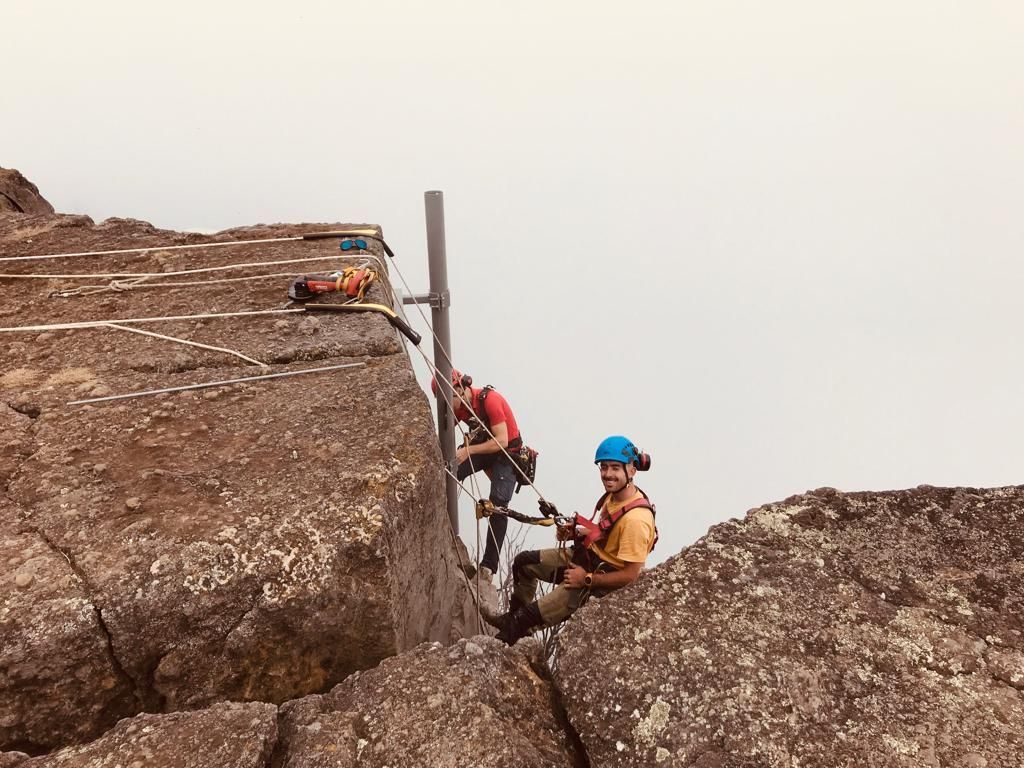 Deux cordistes posant en haut d'un falaise
