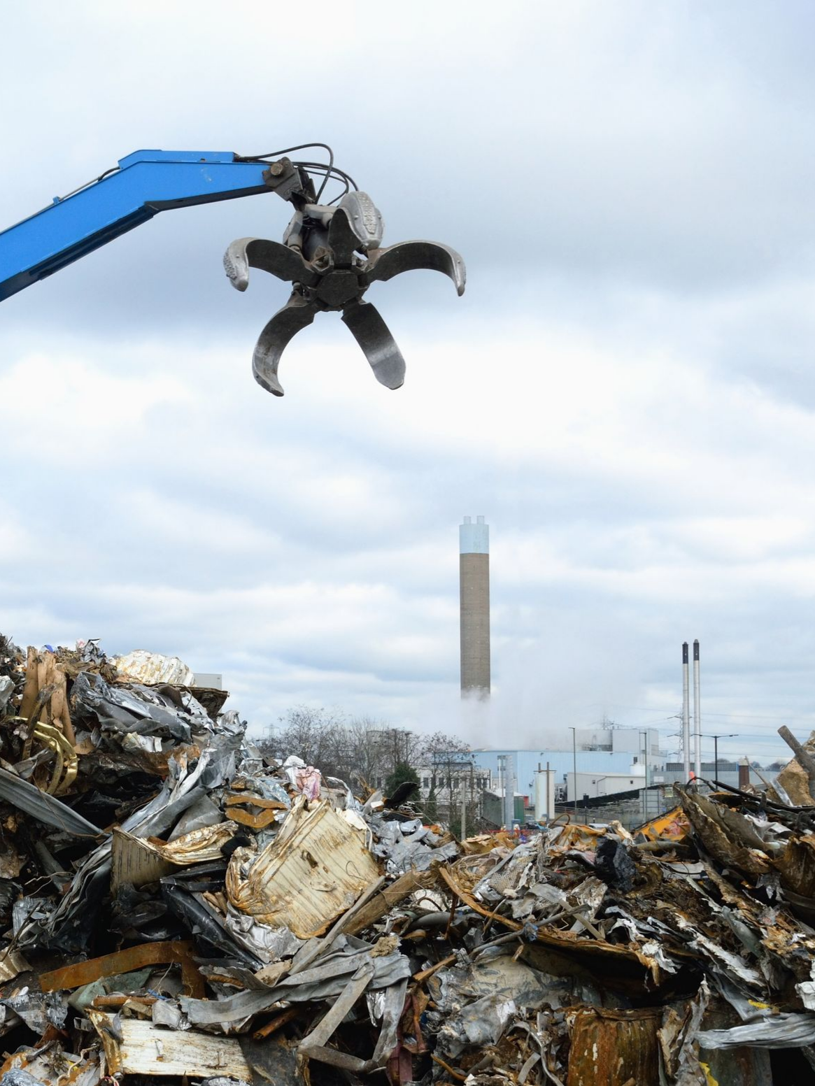 Une grue à griffes soulève des débris.