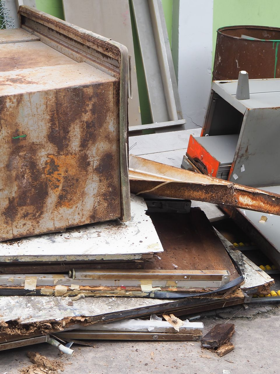 Des objets métalliques rouillés, empilés à l'extérieur.