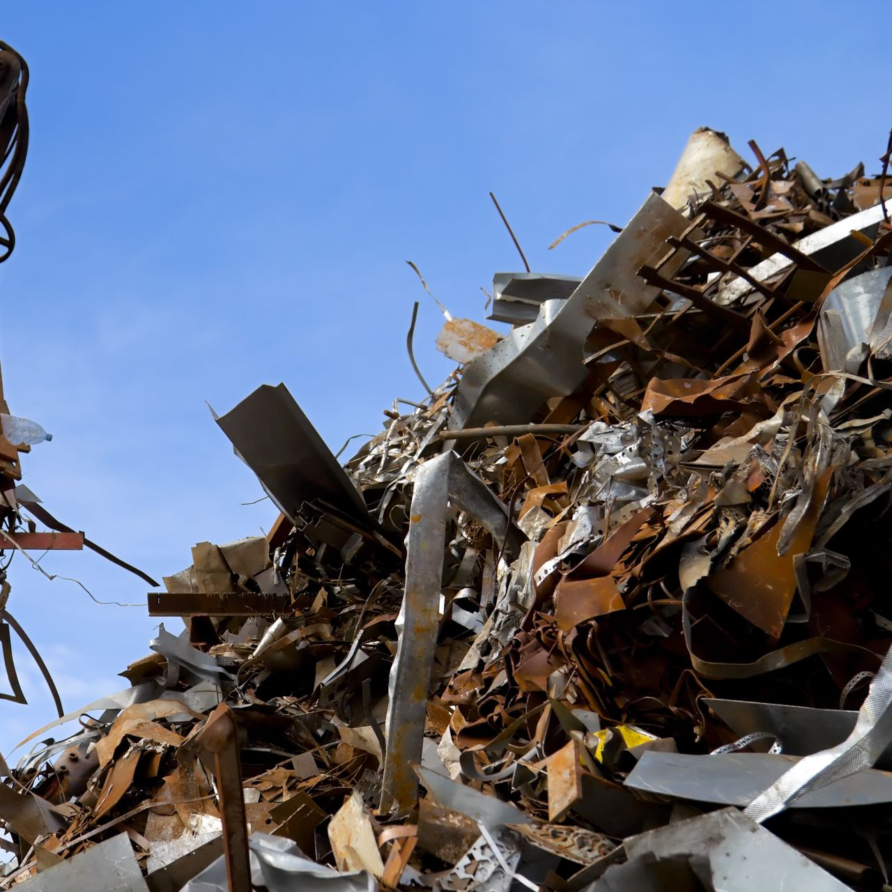 Un tas de ferraille se détachant et présentant diverses textures et formes métalliques.