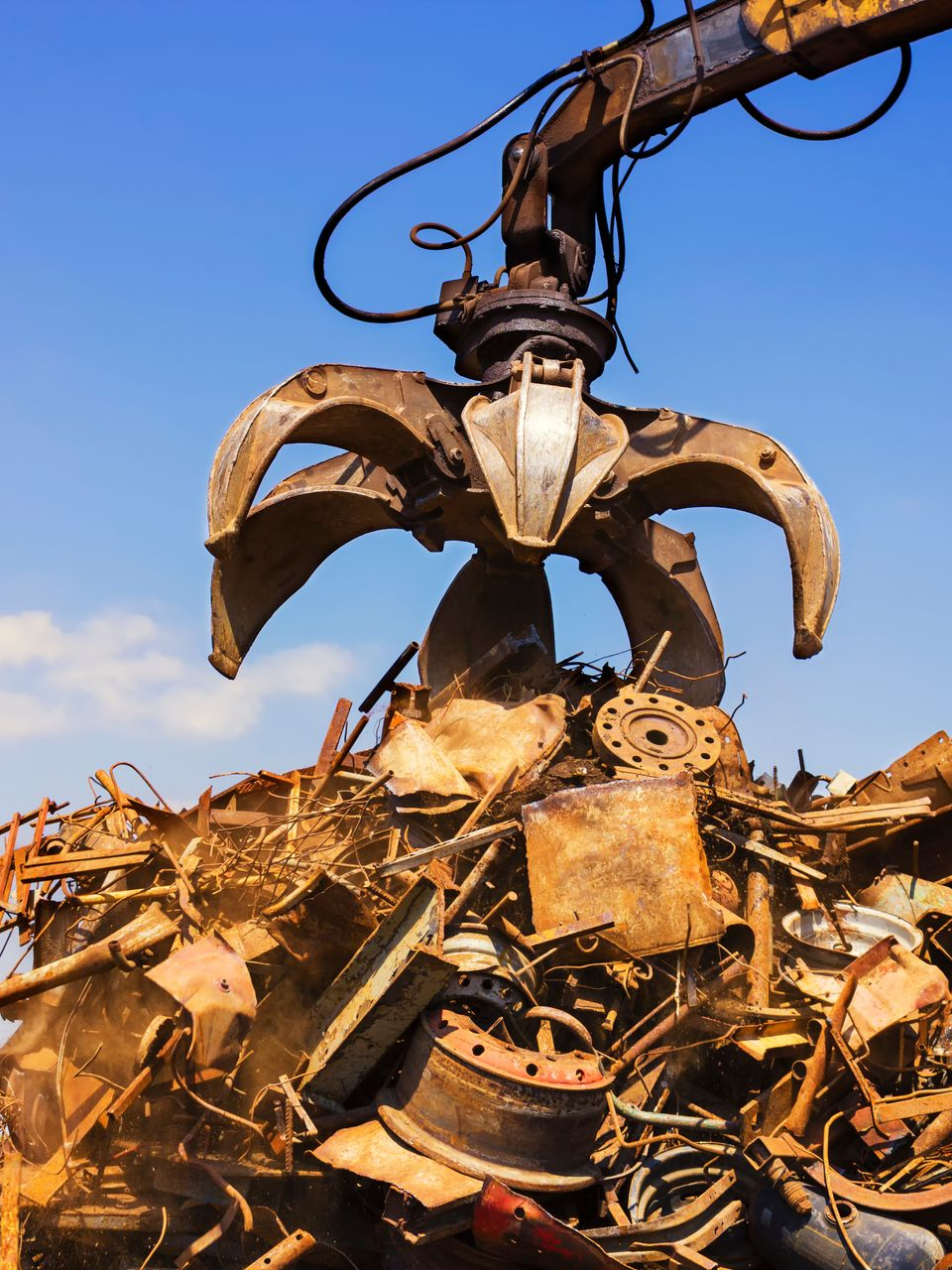 Des morceaux de métal sont soulevés par une grue.