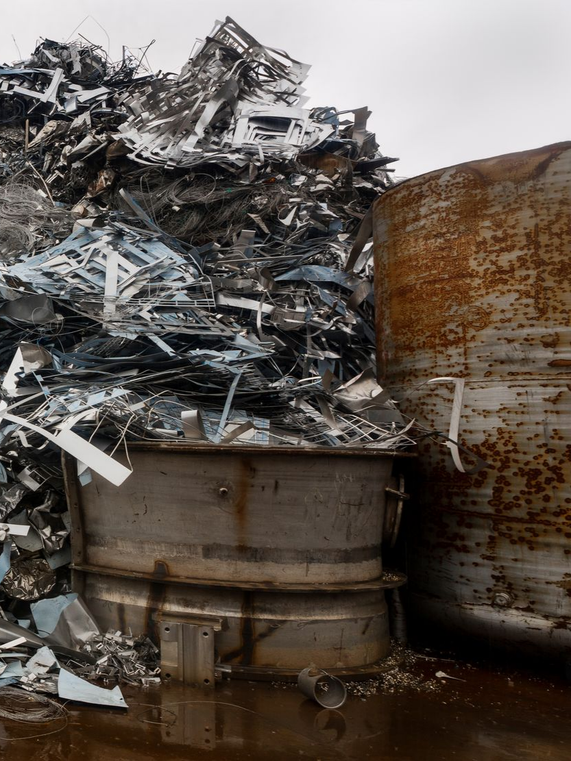 Tas de ferraille et réservoirs cylindriques dans une casse.
