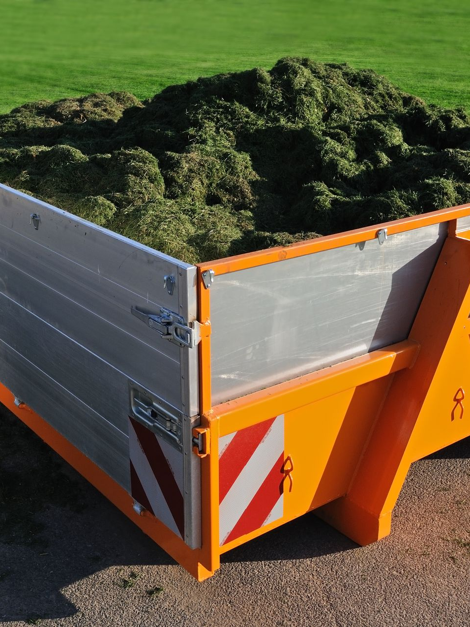 Une benne à ordures remplie de gazon tondu.