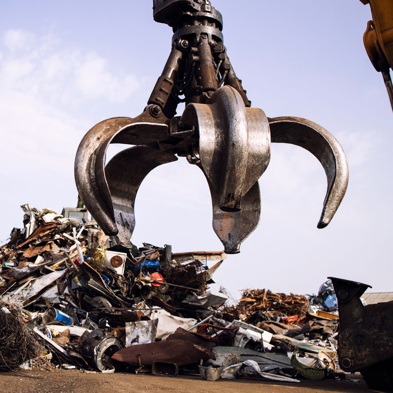 Grue soulevant de la ferraille dans une casse.