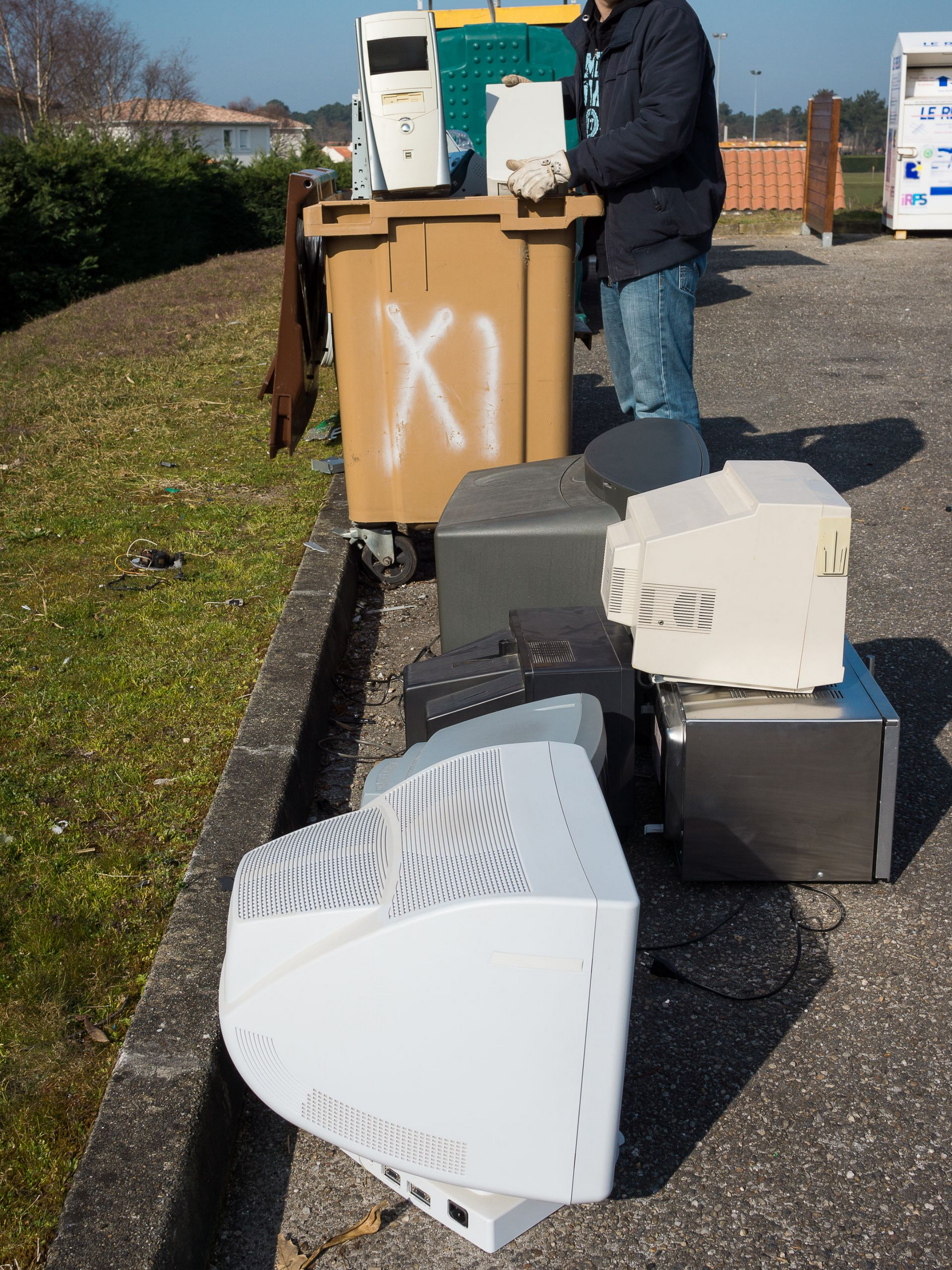 Une benne à ordures remplie de vieux appareils électroniques.