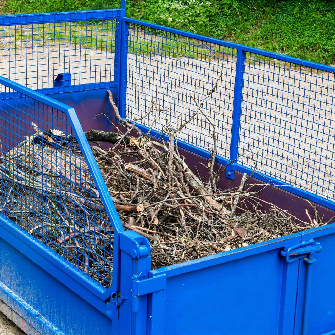 Bac en métal rempli de brindilles et de branches brunes.