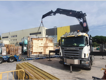 Un camión Scania transporta una gran caja de madera.