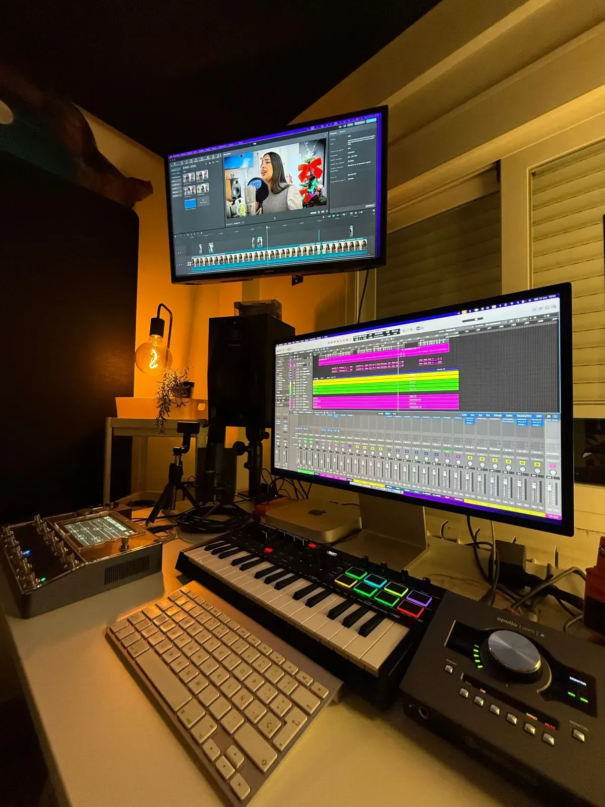 Un estudio casero de producción musical que incluye dos monitores, un controlador de teclado, un teclado y una mesa