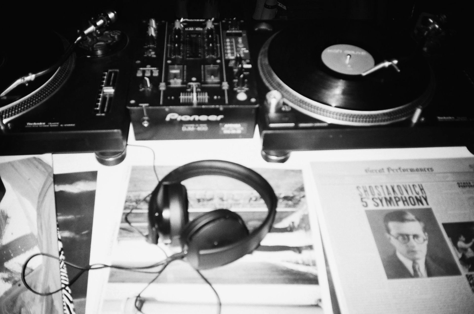 Una fotografía en blanco y negro de un tocadiscos pionero y auriculares.
