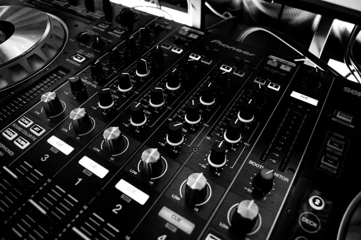 Fotografía en blanco y negro, tomada en primer plano, de una mesa de mezclas Pioneer DJ