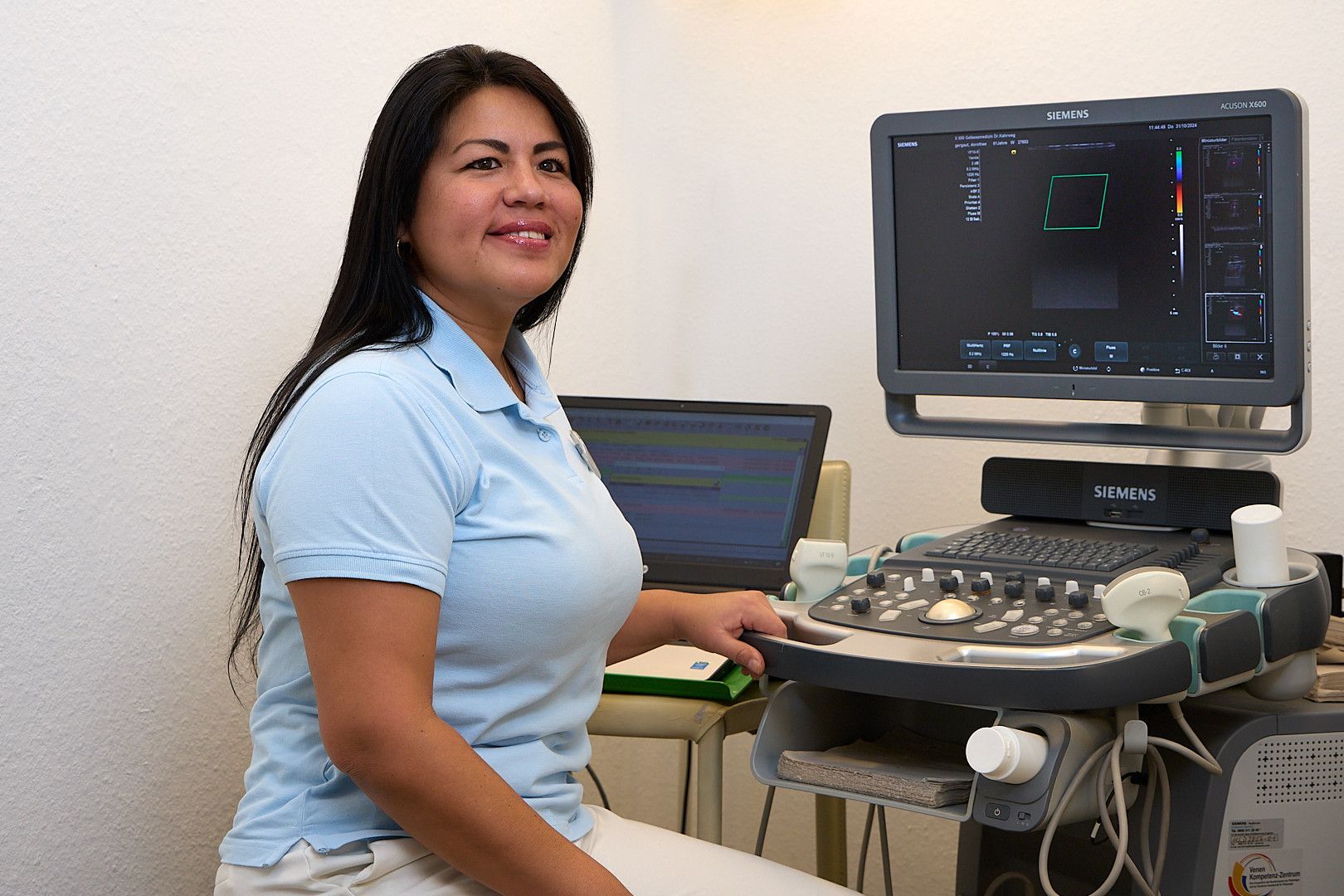 Eine Frau hört mit einem Stethoskop den Herzschlag eines Patienten ab