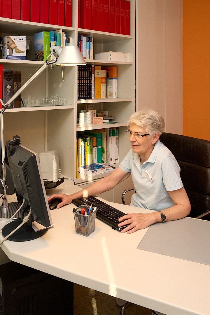 Eine Frau sitzt vor einem Ultraschallgerät.