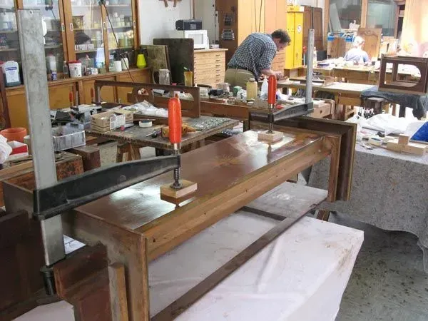 Blick in Werkstatt mit Tisch und Mitarbeiter im Hintergrund, Restaurierungswerkstatt Jörg Nowack und Partner