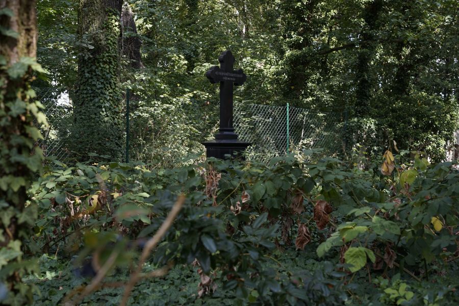 schwarzes Kreuz in bepflanztem Teil vom Friedhof „Vor dem Baruther Tor“
