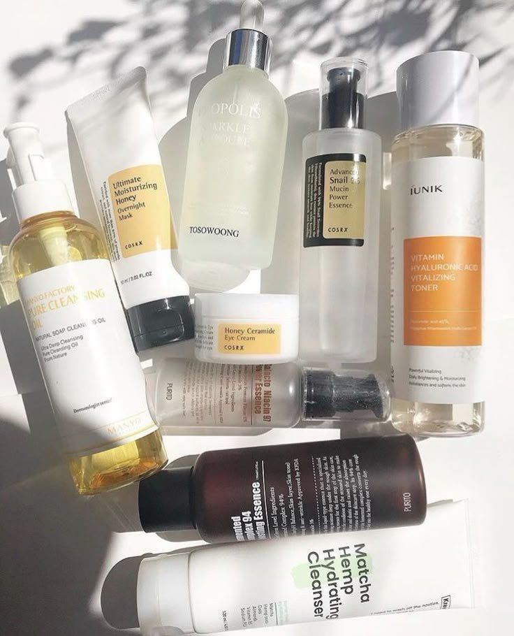 Productos para el cuidado de la piel dispuestos sobre una superficie blanca, en su mayoría botellas transparentes y blancas