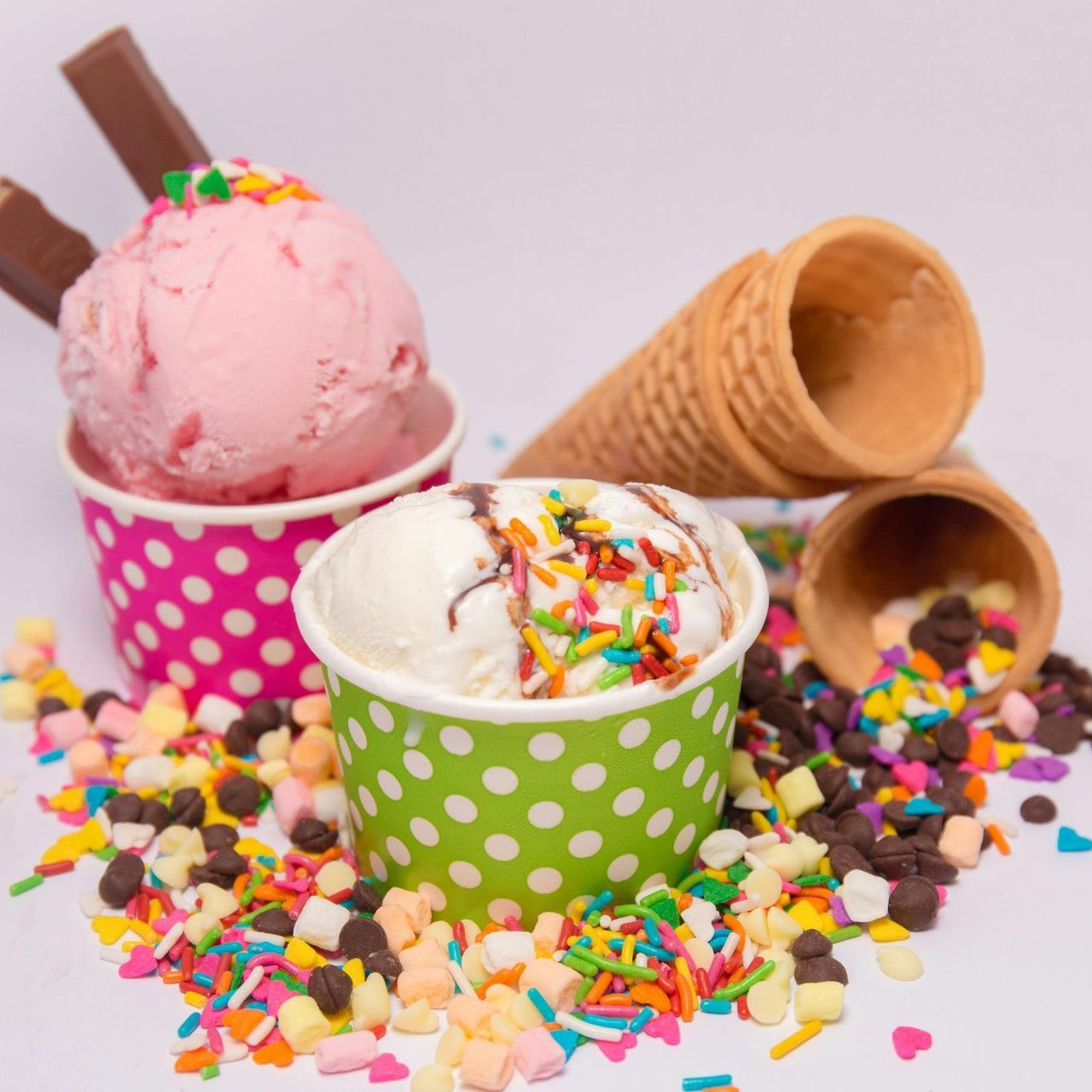 Helado rosa y blanco en vasos de lunares con chispas