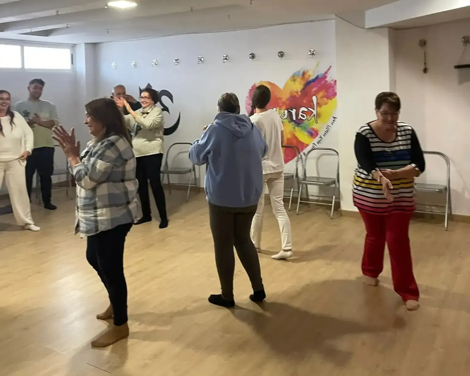 Personas sentadas y arrodilladas en el suelo, haciendo manualidades con revistas y materiales