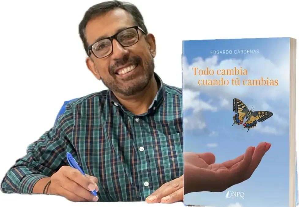 Man smiling, holding a book titled 