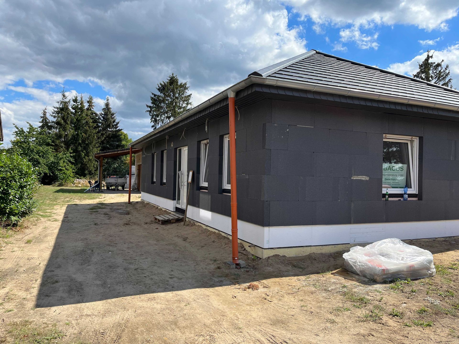 Mitten auf einem Feld wird ein Haus gebaut.