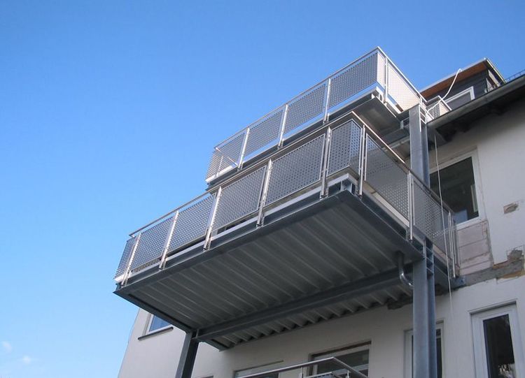 ein Balkon an der Seite eines Gebäudes mit einem blauen Himmel im Hintergrund