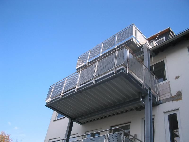 ein Balkon an der Seite eines Gebäudes mit einem blauen Himmel im Hintergrund