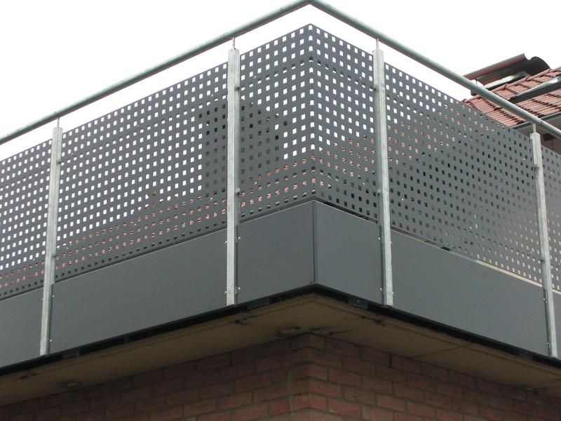 ein Balkon mit einem Metallgeländer auf einem Backsteingebäude