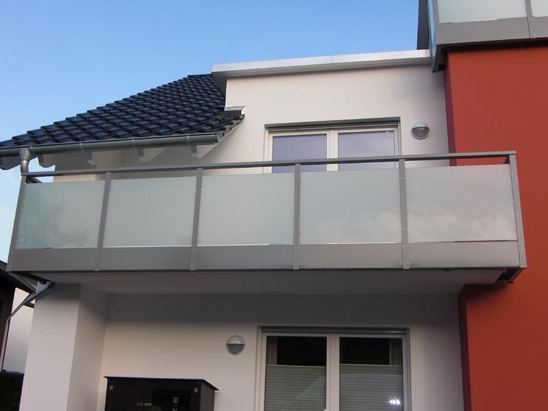 ein rot-weißes Gebäude mit einem Balkon an der Seite