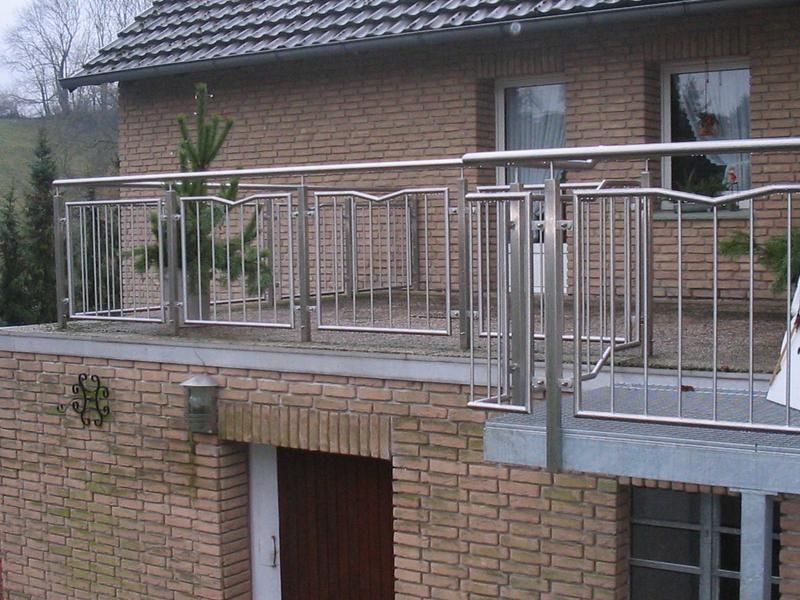 ein Backsteinhaus mit Balkon mit Edelstahlgeländer
