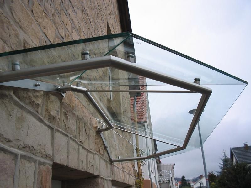 An der Seite eines Gebäudes wird ein Glasdach angebracht