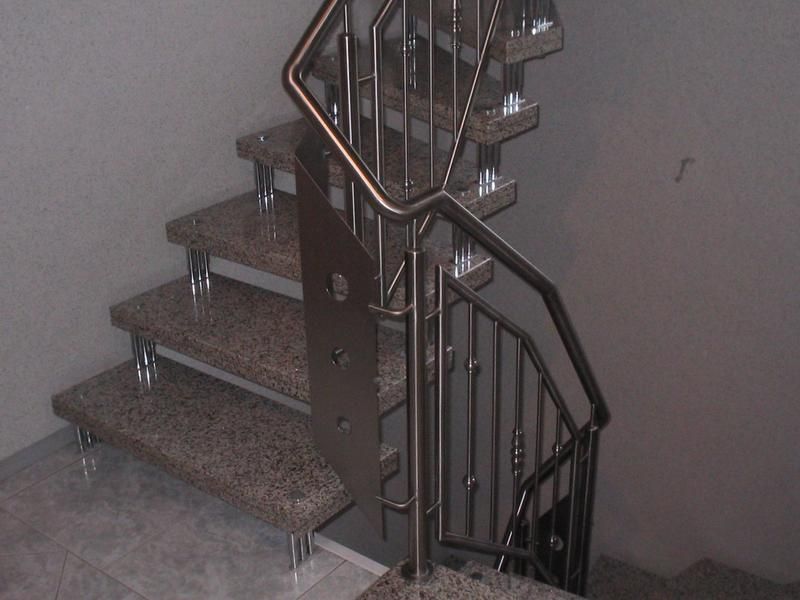 eine Treppe mit Granitstufen und einem Metallgeländer